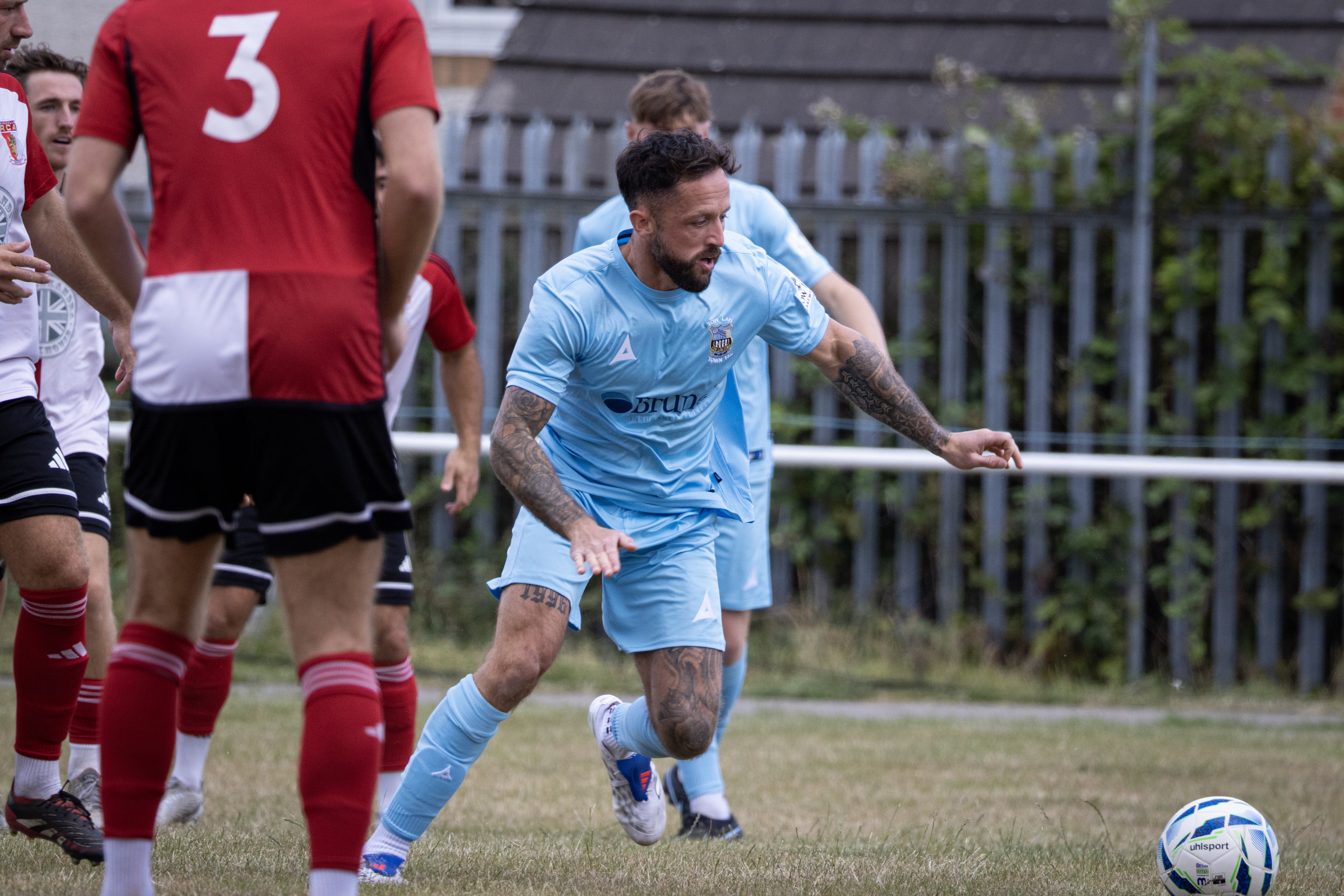 Football player in blue moving toward the ball