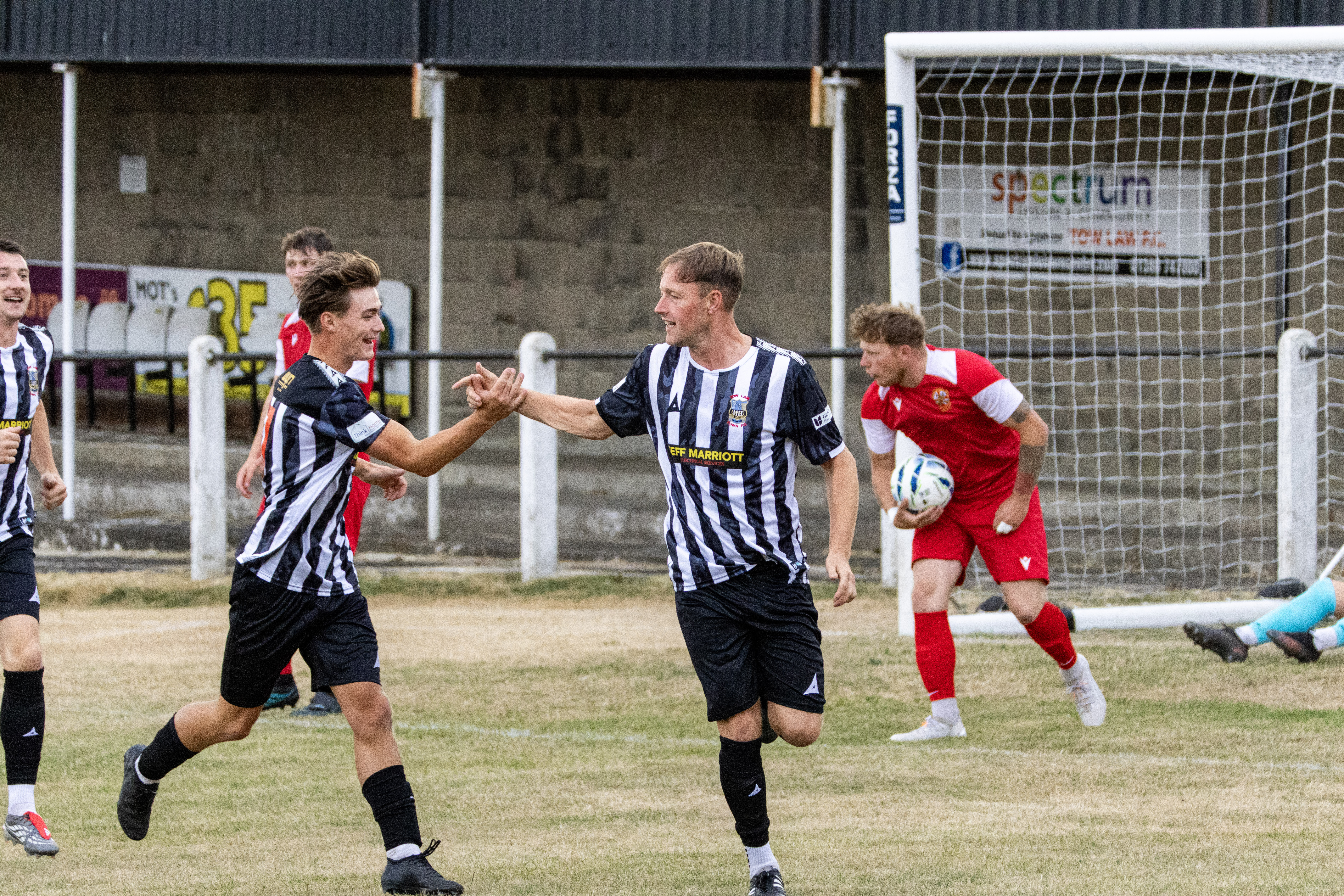 Football teammates celebrating together near the goal