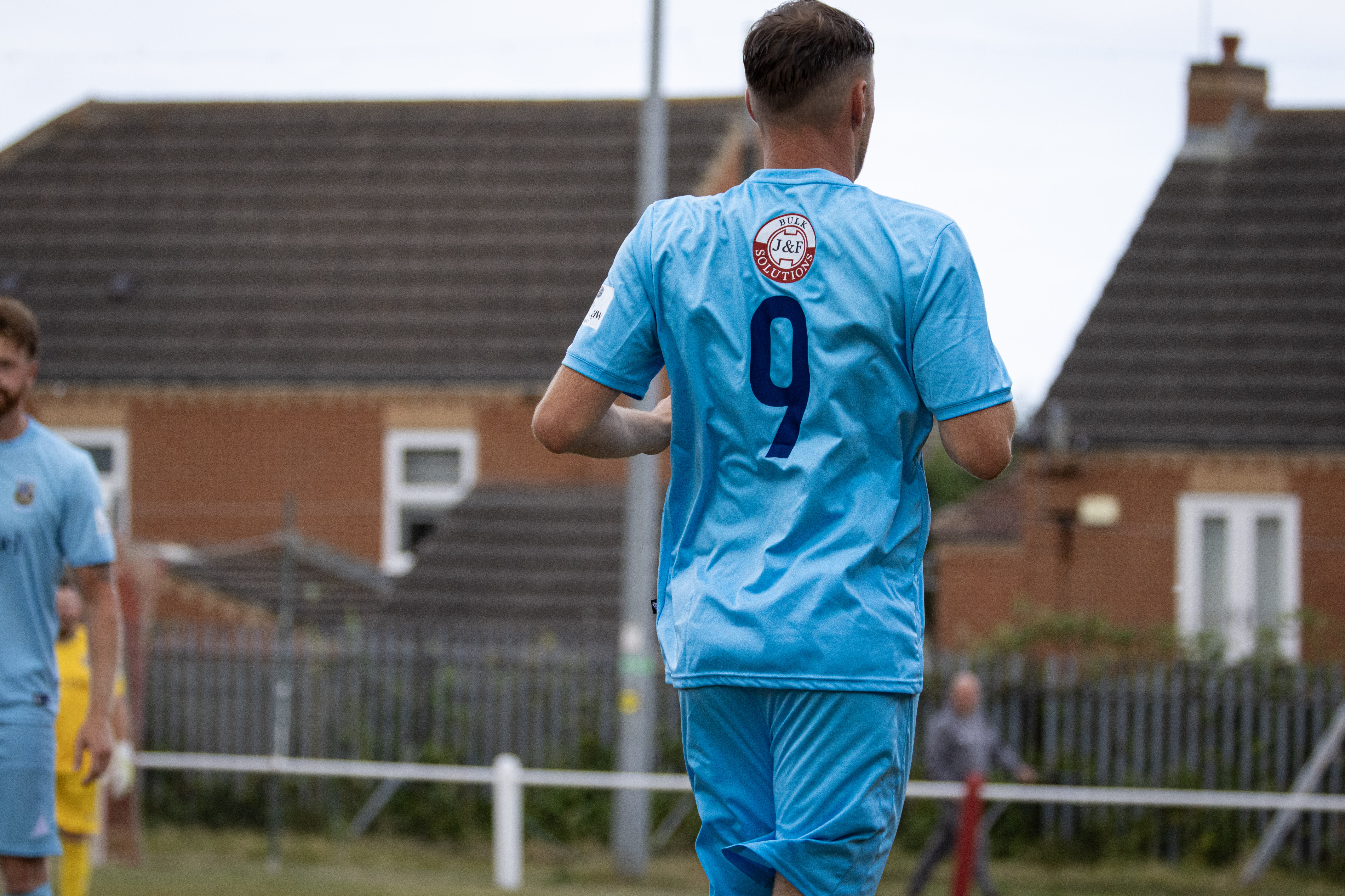 Number 9 football player walking across the pitch